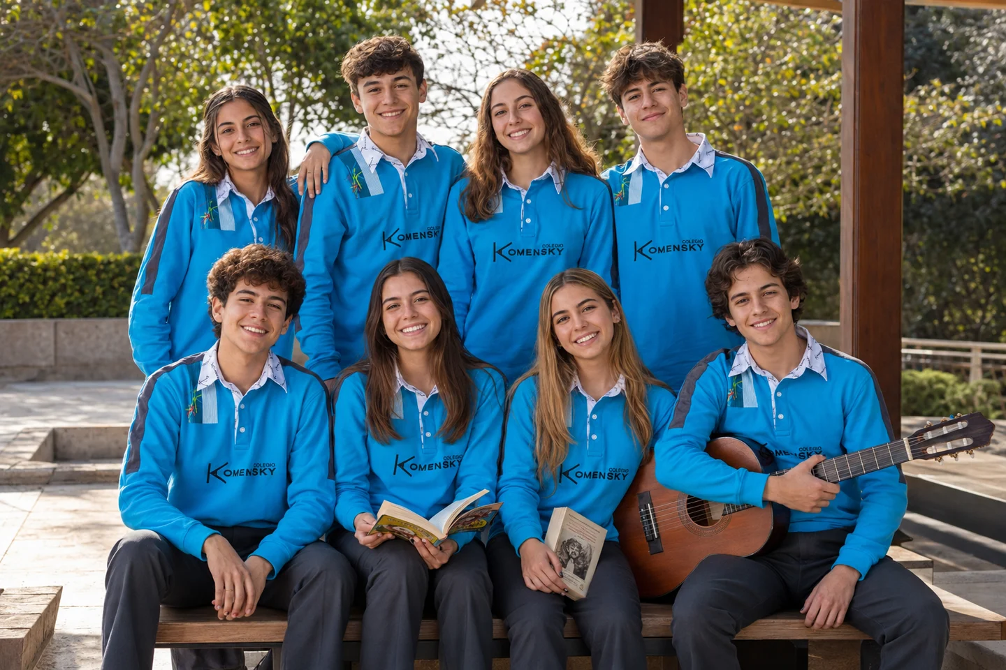 Un grupo de estudiantes con uniforme turquesa comparte libros y una guitarra al aire libre. Imagen referencial.